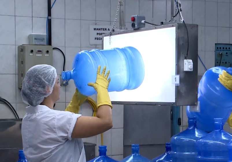 Mulher realizando o processo de tratamento da &aacute;gua.