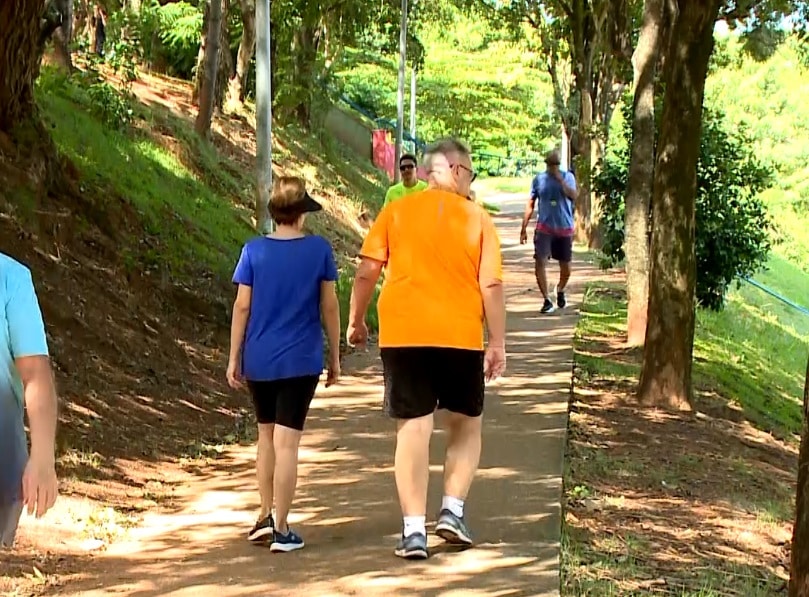 Imagem de casal caminhando em uma pra&ccedil;a.