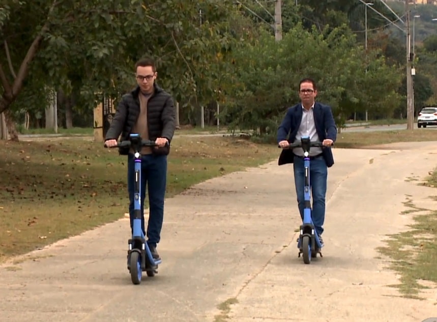 Imagem de duas pessoas andando com o patinete el&eacute;trico.