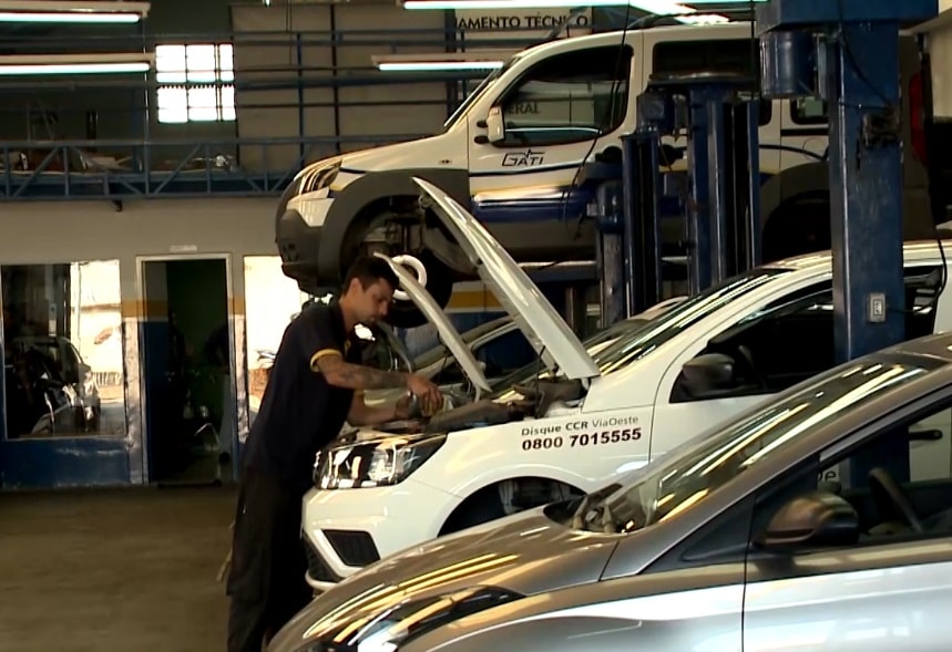 Mec&acirc;nico realizando manuten&ccedil;&atilde;o em um carro.
