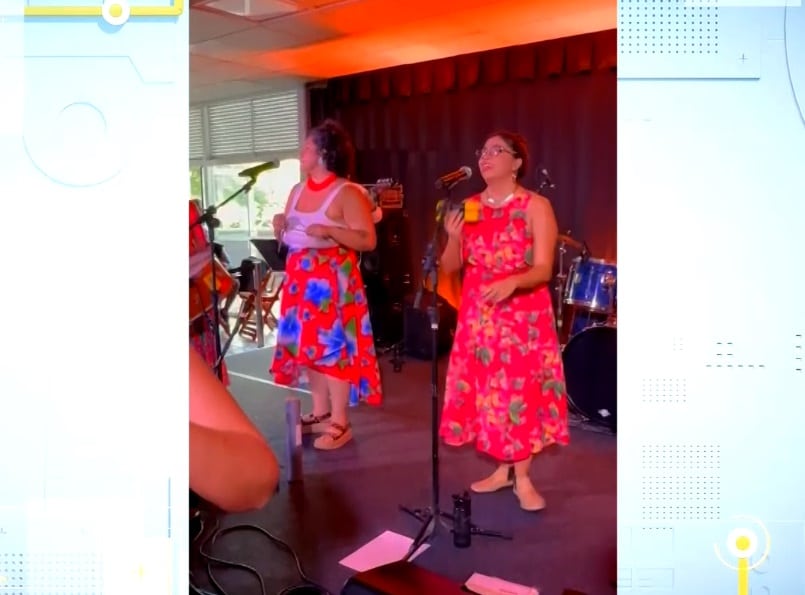 Integrantes do grupo cantando no palco.