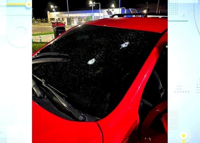 Carro do advogado com marcas de tiro no vidro.