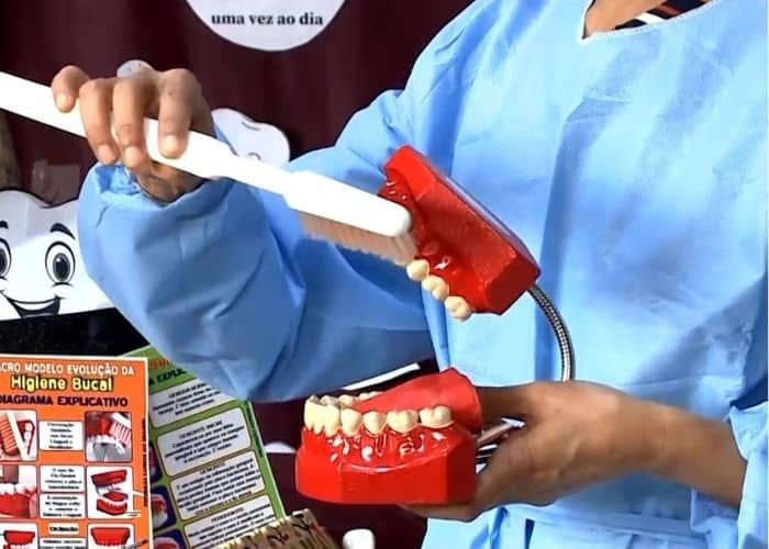 Mulher exemplificando como deve escovar os dentes.