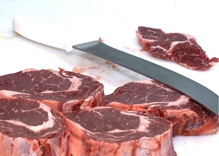Faca e carnes cortadas.