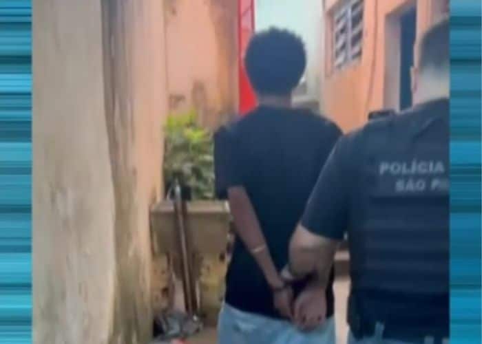 Suspeito sendo levado pela pol&iacute;cia.