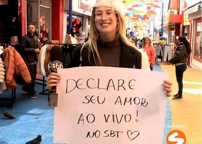 Rep&oacute;rter Nicole Bonentti segurando um cartaz.