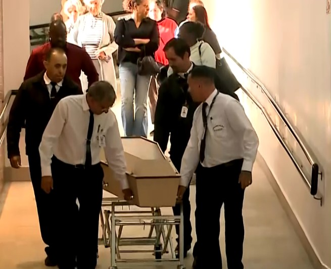 Pessoas levando o caix&atilde;o da v&iacute;tima.