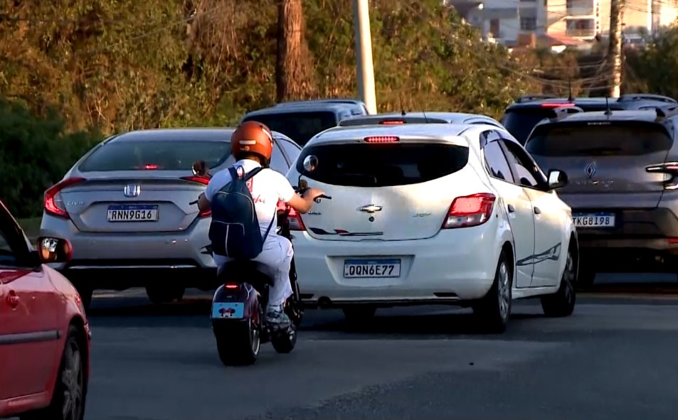 Carros e moto no tr&acirc;nsito.