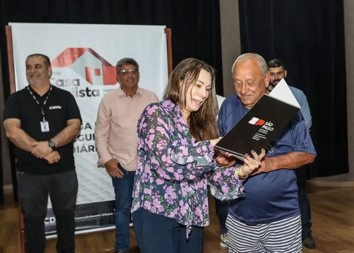 T&iacute;tulo sendo entregue para morador
