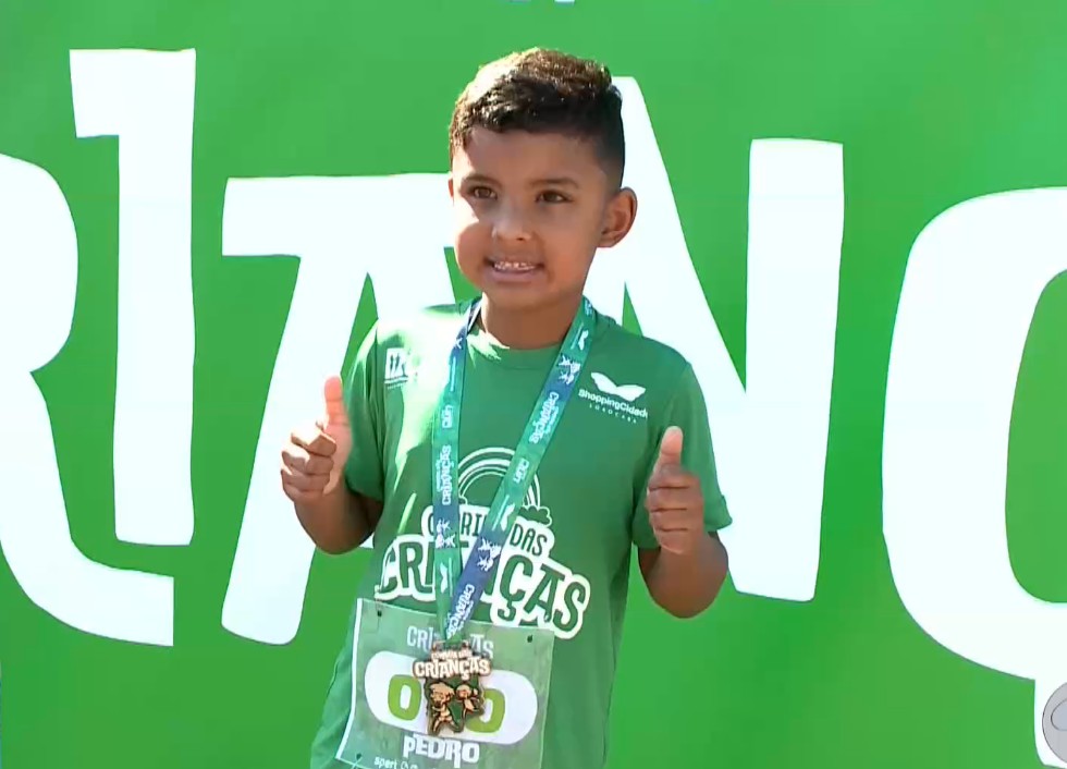 Menino com medalha da Corrida das Crian&ccedil;as feita em Sorocaba.