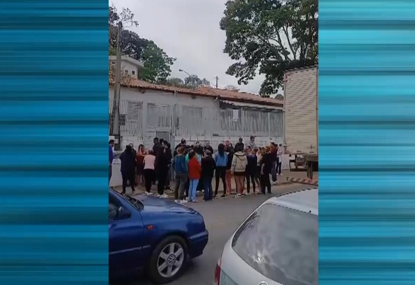 Pessoas reunidas em frente a escola.