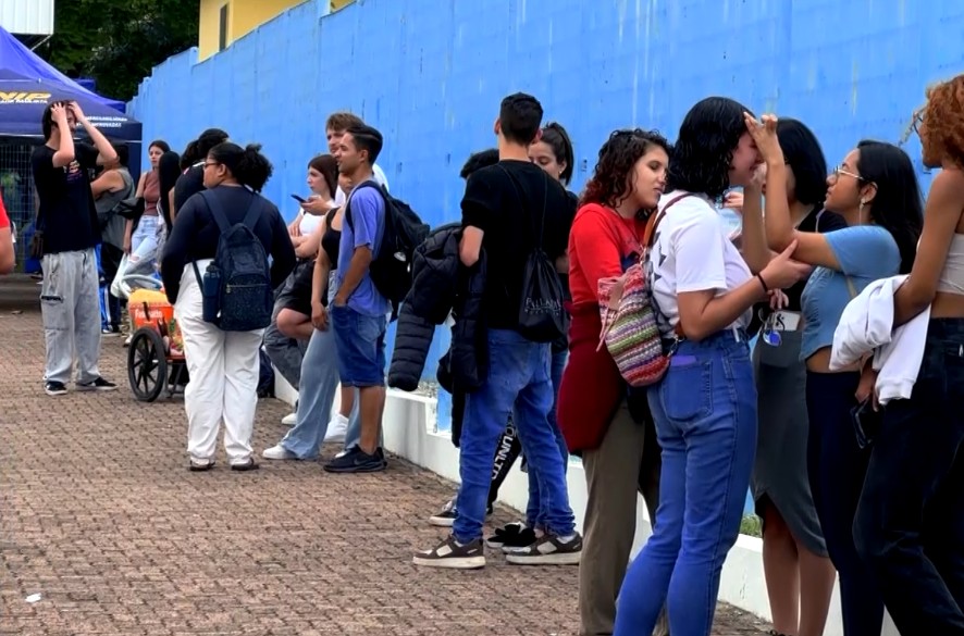 Alunos reunidos em frente &agrave; uma universidade.