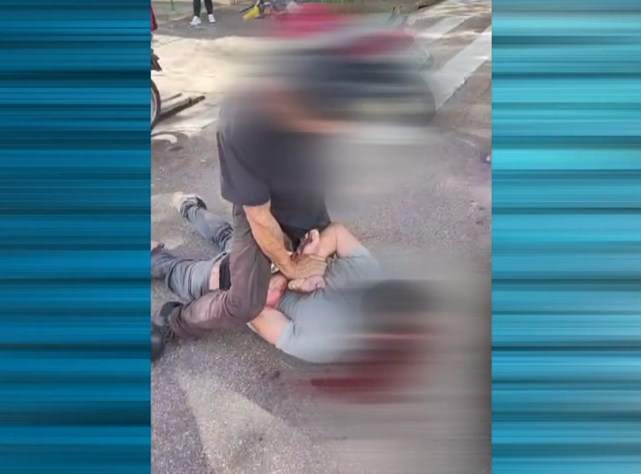 Imagem de homem mobilizando o suspeito, que est&aacute; no ch&atilde;o com a imagem borrada.