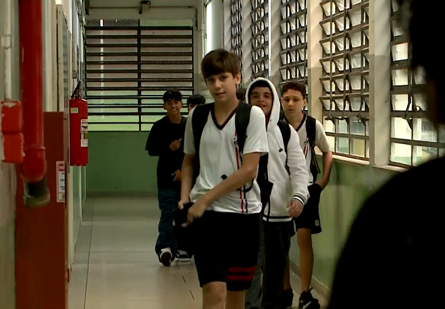 Alunos em corredor de escola.