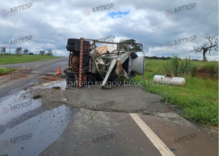 Imagem do caminh&atilde;o tombado e carga derramada sob a pista